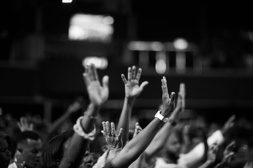 pexels photo 2014775 2014775 A group of people raising hands in a black and white concert setting, showing unity and celebration.